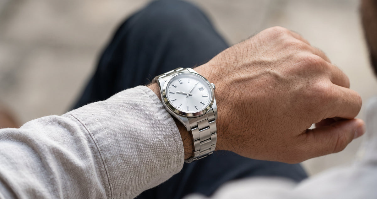 Steel watch bracelet on the wrist with a linen shirt cuff